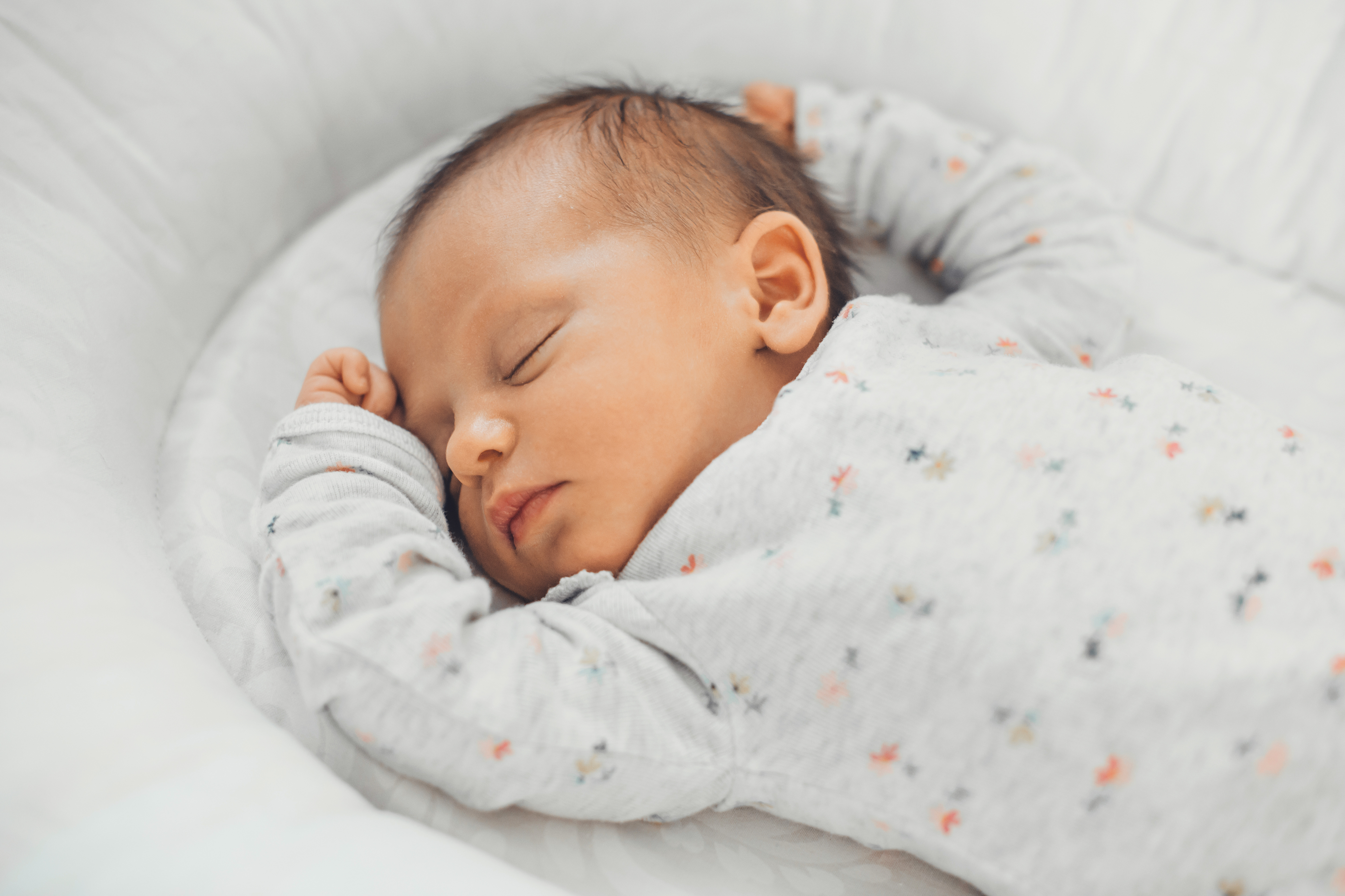 
    
            
                    Bild zeigt ein friedlich schlafenden Baby von oben auf weißer Bettwäsche.
                
        
